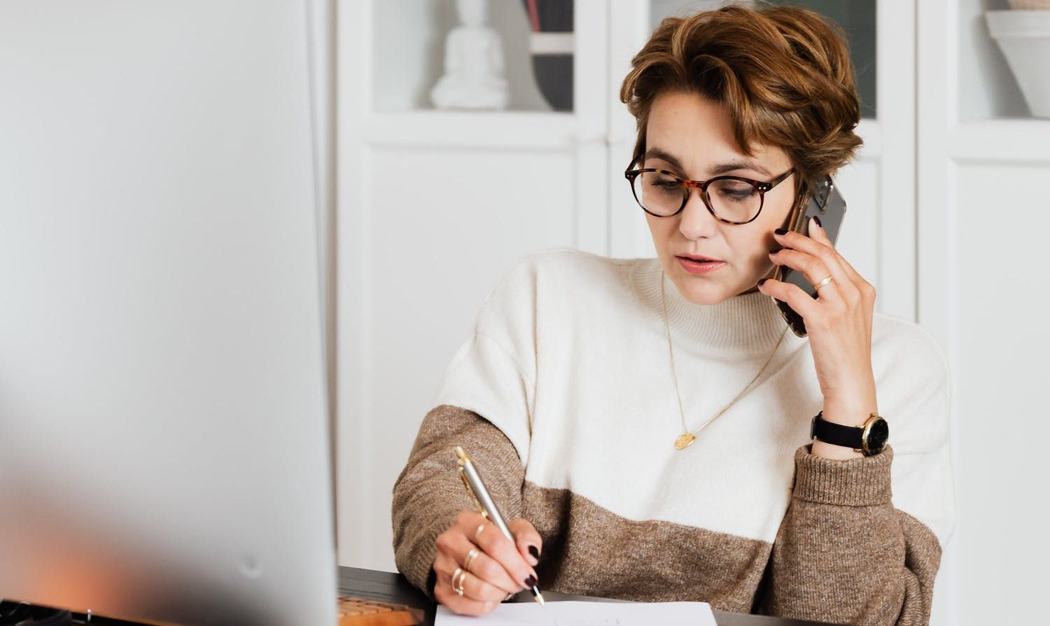 Modern businesswoman in casual outfit talking on mobile in office